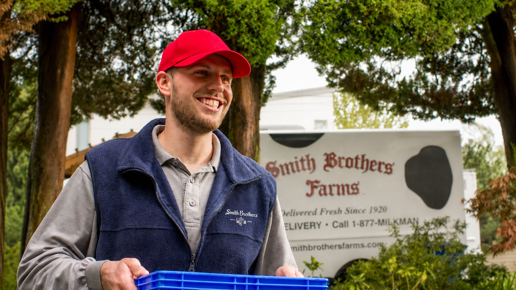 Smith Brothers driver delivering a crate of fresh groceries